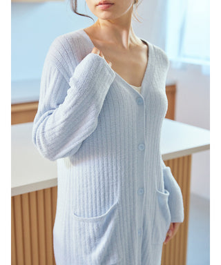 Woman wearing a blue Thermal Smoothie Long Cardigan with ribbed texture, showcasing its cozy and elegant design in a bright room.