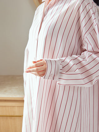 Close-up of a person wearing a Gelato Pique USA striped long sleeve pajama shirt, showcasing its elegant design and silky texture.