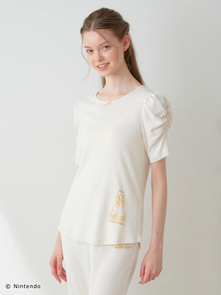 Model wearing Peach Collection Puff Sleeve Top in ivory with subtle dot texture by GELATO PIQUE, offering elegance and versatility.