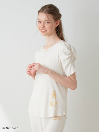 Model wearing Peach Collection Puff Sleeve Top in ivory with delicate dot texture, showcasing casual elegance from GELATO PIQUE.
