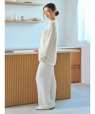 Woman wearing white Thermal Smoothie Pullover Sweater in a stylish cozy room.