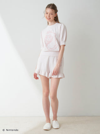 Woman wearing Gelato Pique Peach Collection pullover and shorts set with puff sleeves and ruffles, crafted from lightweight Airy Moco fabric.