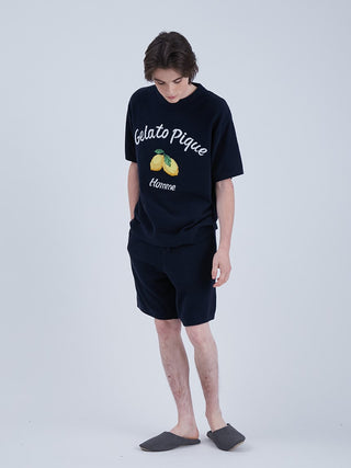 Man wearing Airmoco ultra comfy men's lounge shorts with lemon design, paired with Gelato Pique t-shirt, standing indoors.