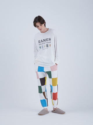 Model wearing EAMES House of Cards Men's Long Sleeve Tee, featuring mid-century design and HOMME's bear logo, paired with colorful pants.
