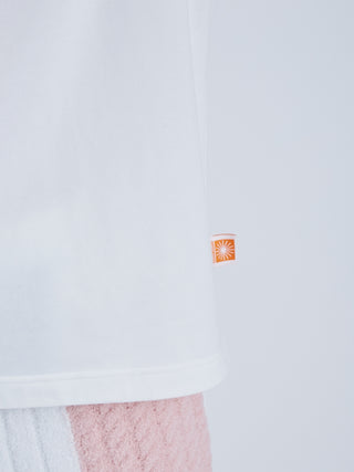Close-up of white EAMES House of Cards Men's Long Sleeve Tee with orange stitched logo, showcasing mid-century inspired design.