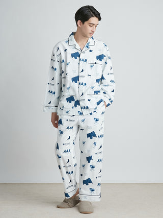 Man wearing EAMES Chair Motif lounging pajamas in navy and white print, featuring mid-century design, made from recycled cotton.