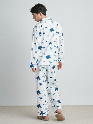 Model wearing EAMES Chair Motif men's lounging pajamas in navy print, made from recycled cotton, showcasing mid-century style design.