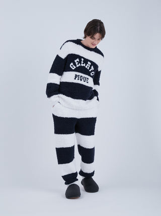 Model wearing Sustainable Double Striped Men's Fluffy Pajama Pants in green and navy with "recycled gelato" fabric, eco-friendly style.