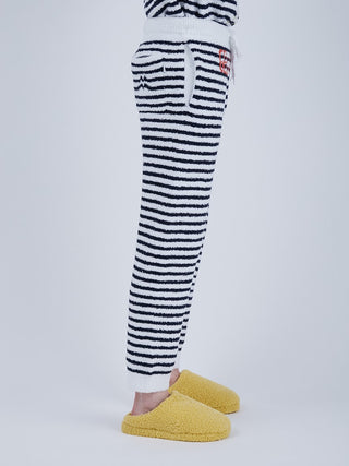 Side view of Baby Moco Duck Stripe Men's Long Lounge Pants with duck pattern, plush fabric, and yellow slippers.