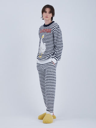 Man wearing Baby Moco Duck Stripe Men's Long Lounge Pants with duck pattern and striped design, paired with yellow slippers.