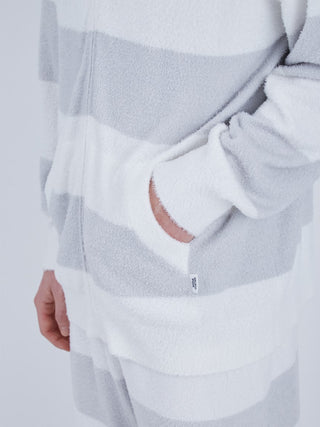 Close-up of a men's striped zip-up hoodie with a soft texture and neutral colors, showing side pocket and stripe detail.
