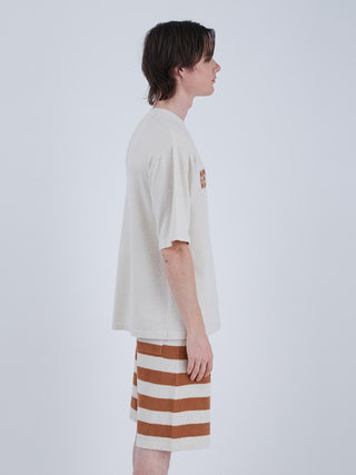 Side view of a model wearing the Smoothie Logo Men's Loungewear Set, featuring a beige top and striped shorts, ideal for warm weather comfort.