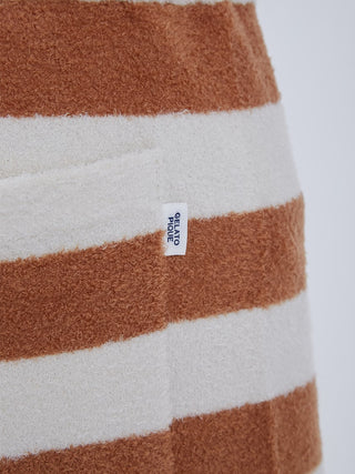 Close-up of brown and white striped textured loungewear fabric with a brand label tag.