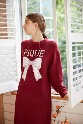 Woman wearing a burgundy Ribbon Jacquard Dress with a white bow motif, showcasing loungewear elegance by Gelato Pique.