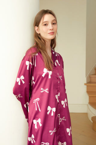 Woman wearing ribbon pattern satin shirt dress with bow print, showcasing elegant loungewear style.