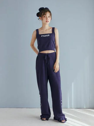 Model wearing Gelato Pique loungewear set in dark blue, featuring a cropped tank top and matching relaxed-fit pants.