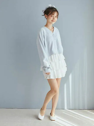 Woman wearing Airy Moco Tiered Mini Skirt with light sweater, showcasing elegant casual style.