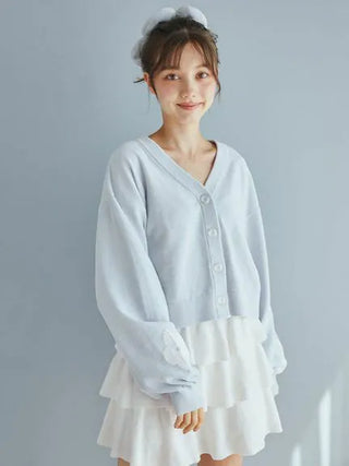 Woman wearing Airy Moco Tiered Mini Skirt with light blue cardigan, showcasing comfortable and elegant loungewear fashion.