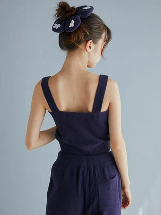 Model wearing Airy Moco Flower Logo Jacquard Cropped Tank Top in deep navy, showcasing back view with stylish hair accessory.