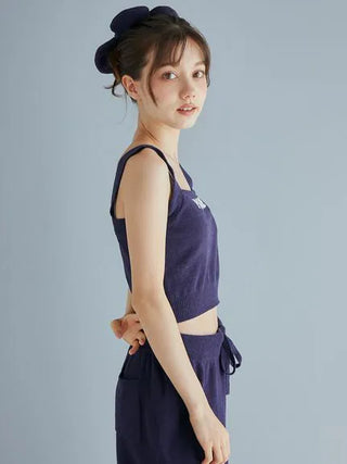 Woman wearing Airy Moco Flower Logo Jacquard Cropped Tank Top in deep navy, showcasing the soft and stylish casual look for lounging.