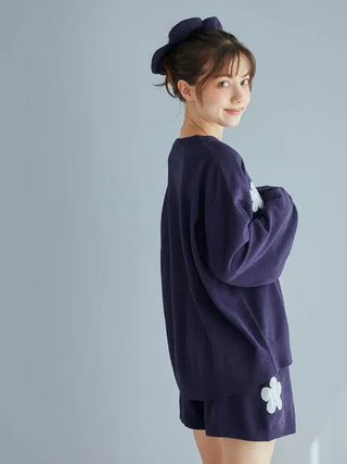 Woman wearing Airy Moco Flower Logo Jacquard Pullover Sweater in dark color, showcasing side profile with floral design detail.