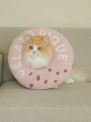 Cat wearing a pink Gelato Pique cozy premium donut neck pillow on a sofa, part of the CAT & DOG loungewear collection.