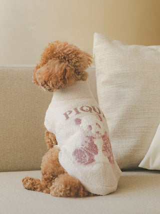 Brown dog wearing white Gelato Pique USA high-neck pet clothes with panda design, sitting on a beige couch. Premium loungewear and sleepwear.