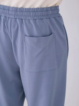 Close-up of men's blue lounge pants with side pocket and elastic waistband, featuring a subtle star pattern.