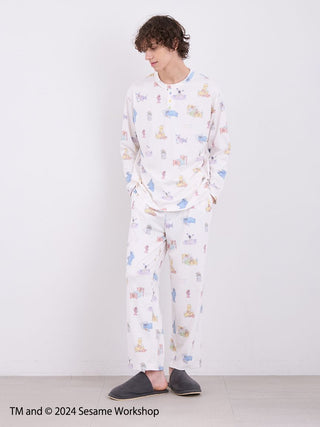 Model wearing SESAME STREET men's colorful all-over print long pants made from soft rayon-blend fabric, styled for relaxation.