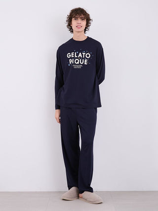 Model wearing Men's Inlay Star Logo Lounge Pants in navy, featuring Gelato Pique logo, paired with matching top and slippers.