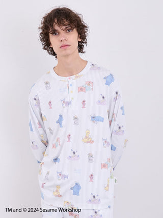 Model wearing Sesame Street men's all-over print Henley pullover in colorful gelato pique style, featuring soft rayon-blend fabric.