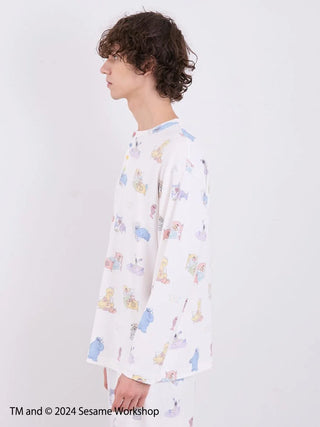 Model wearing Sesame Street men's all-over print pullover in colorful gelato pique design, side view with Henley neck and soft fabric.