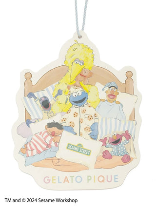 Sesame Street characters in pajamas illustration on a Gelato Pique tag, featuring Big Bird, Cookie Monster, and others on a bed.