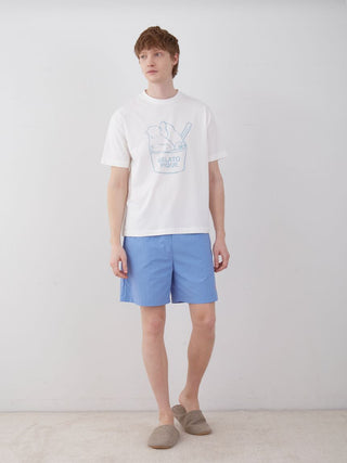 Man wearing COOL MEN'S nylon lounge shorts in vibrant blue, paired with a casual white t-shirt and slippers, standing against a plain background.