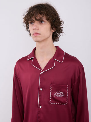 Model wearing burgundy satin sleep shirt with white piping and pocket embroidery.