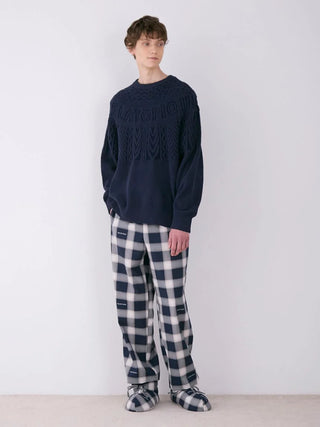 Model wearing MEN'S Air Moco Aran Pullover Sweater with plaid pants, showcasing luxurious Aran detailing and ultra-lightweight fabric.