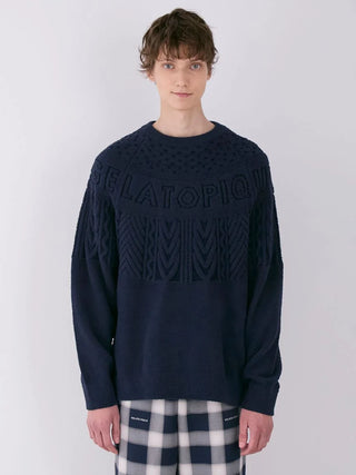 Model wearing men's Air Moco Aran pullover sweater with classic Aran knit detailing by Gelato Pique in navy blue.