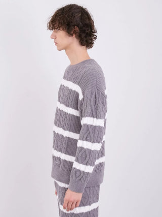 Side view of a man wearing a gray and white Baby Moco Aran Border Pullover Sweater, featuring cable knit design and horizontal stripes.