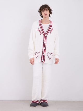 Cozy white feather-textured cardigan with red accents, button-up design, modeled indoors, showcasing festive comfort and style.