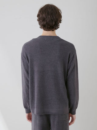 Back view of a person wearing a dark gray long-sleeve sweater and matching pants, standing against a neutral background.