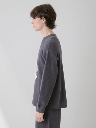 Side view of a model wearing a dark-colored pullover and lounge shorts loungewear set from Gelato Pique USA.