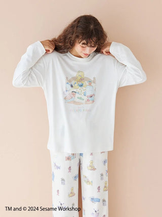 Unisex Sesame Street pullover featuring Elmo and Cookie Monster pajama party print in white rayon-blend fabric, worn by model.