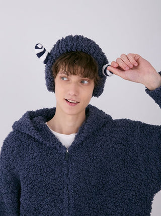 Young man wearing a PIQUE MONSTER Headband with plush monster design, perfect for Halloween. Cozy, fluffy material in dark color.