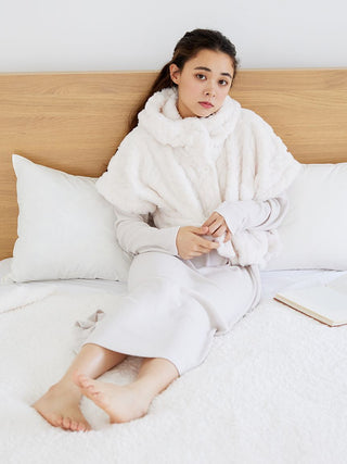 Woman wearing the Snow Lounge Maxi Dress, relaxing on a bed with cozy pillows, showcasing comfort and simplicity in loungewear.