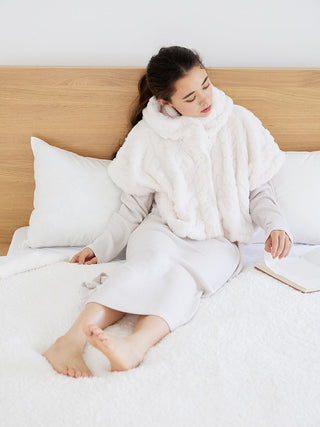 Woman relaxing in Gelato Pique Snow Lounge Maxi Dress on bed, showcasing soft, comfortable loungewear.