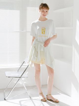 Woman wearing ombre lounge shorts and a casual t-shirt in a bright room with a minimalist chair.