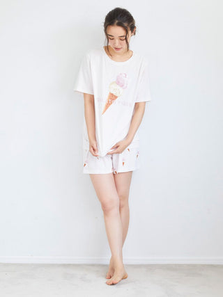 Woman wearing ice cream print lounge shorts and matching shirt; playful summer homewear, soft fabric for comfort and relaxation.