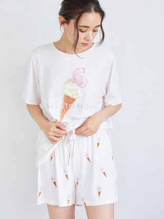 Woman wearing ice cream print lounge shorts and top, showcasing a whimsical, summery design for comfortable loungewear.