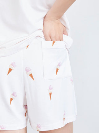 Person wearing white lounge shorts with ice cream print, showcasing playful and comfortable loungewear fashion.