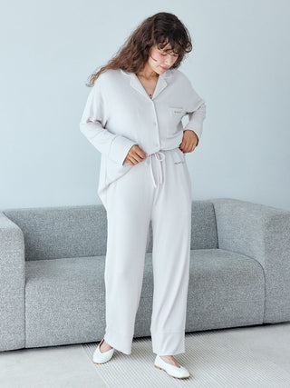 Woman wearing Gelato Pique Snow Lounge Pants in heather gray, standing in a modern living room, highlighting comfort and style.